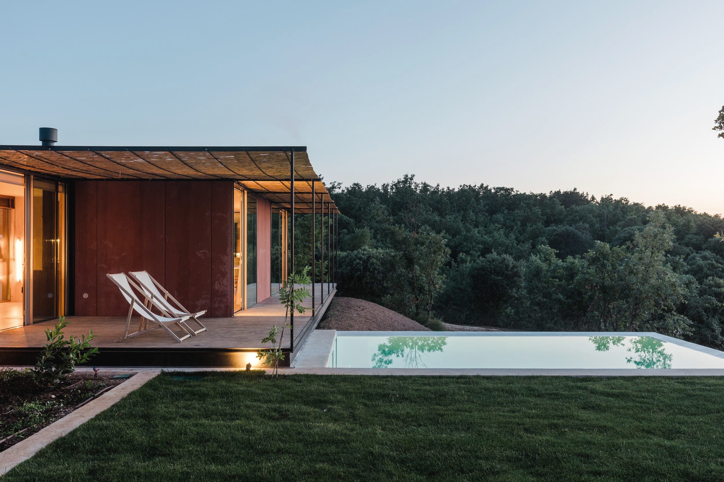 A Tini M modular house with terrace and pool at dusk